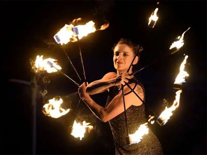 Artiste de cirque tenant des bâtons enflammés dans les mains